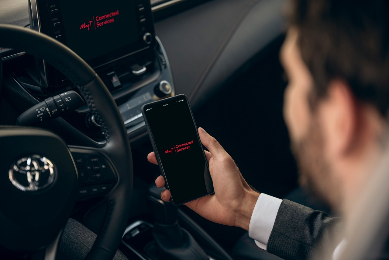 Mann schaut im Auto auf sein Handy