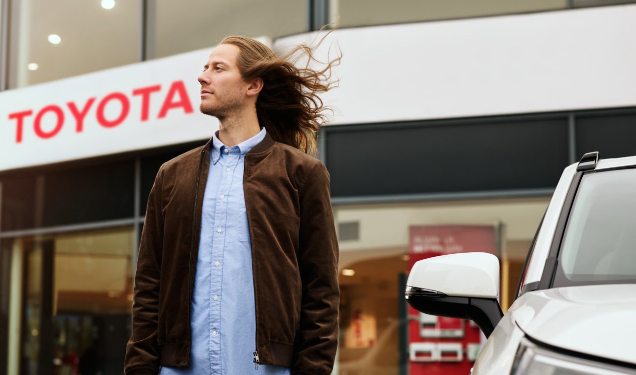 Mann vor einem Toyota Händler