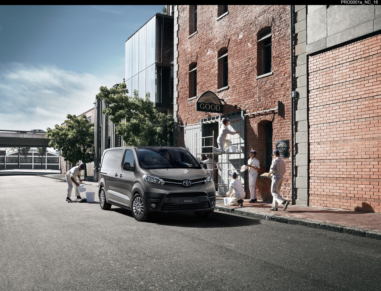 Maler beim Streichen eines Hauses vor einem Toyota Proace Firmenwagen