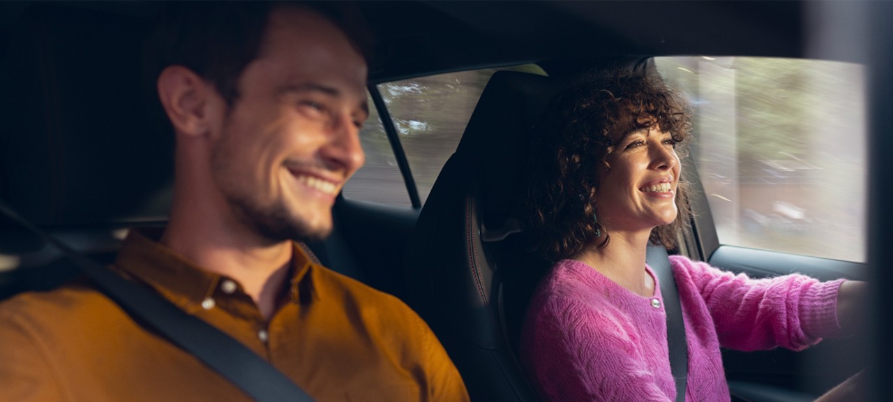 Frau und Mann sitzen lächelnd in einem Toyota
