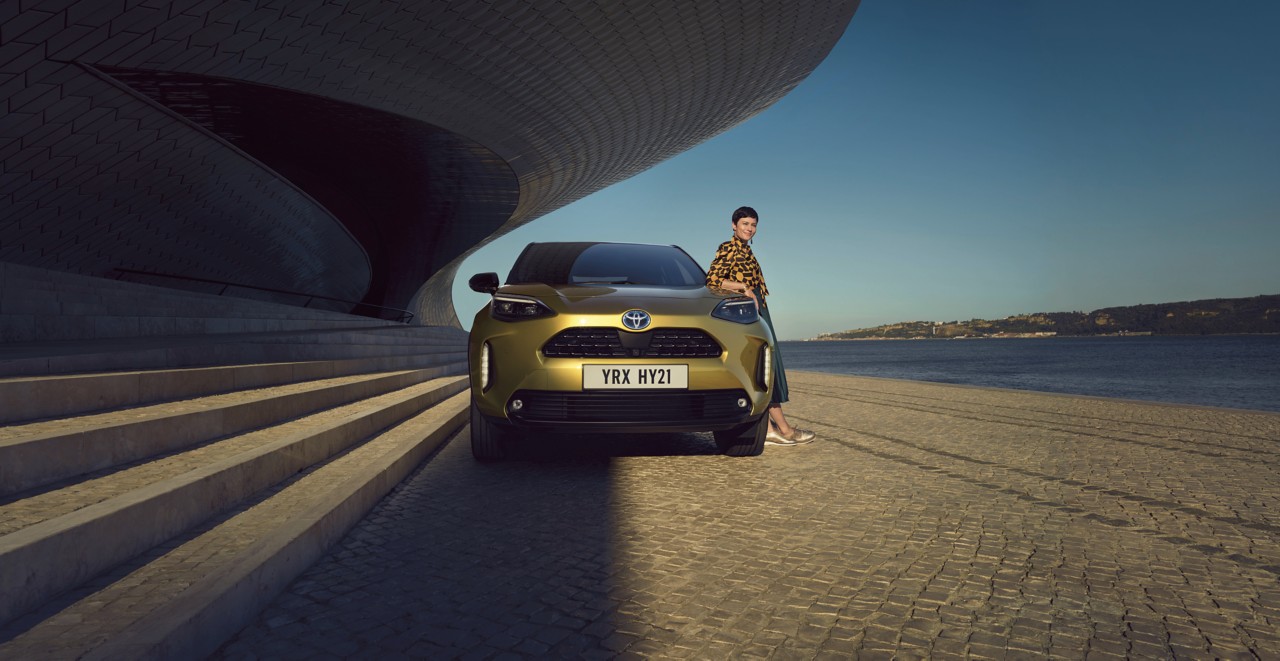 Junge Frau neben einen Yaris Cross