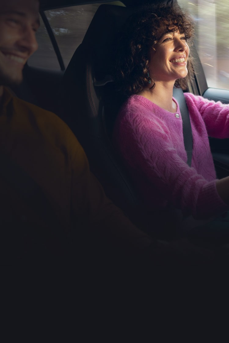 Frau fährt im Auto und lächelt