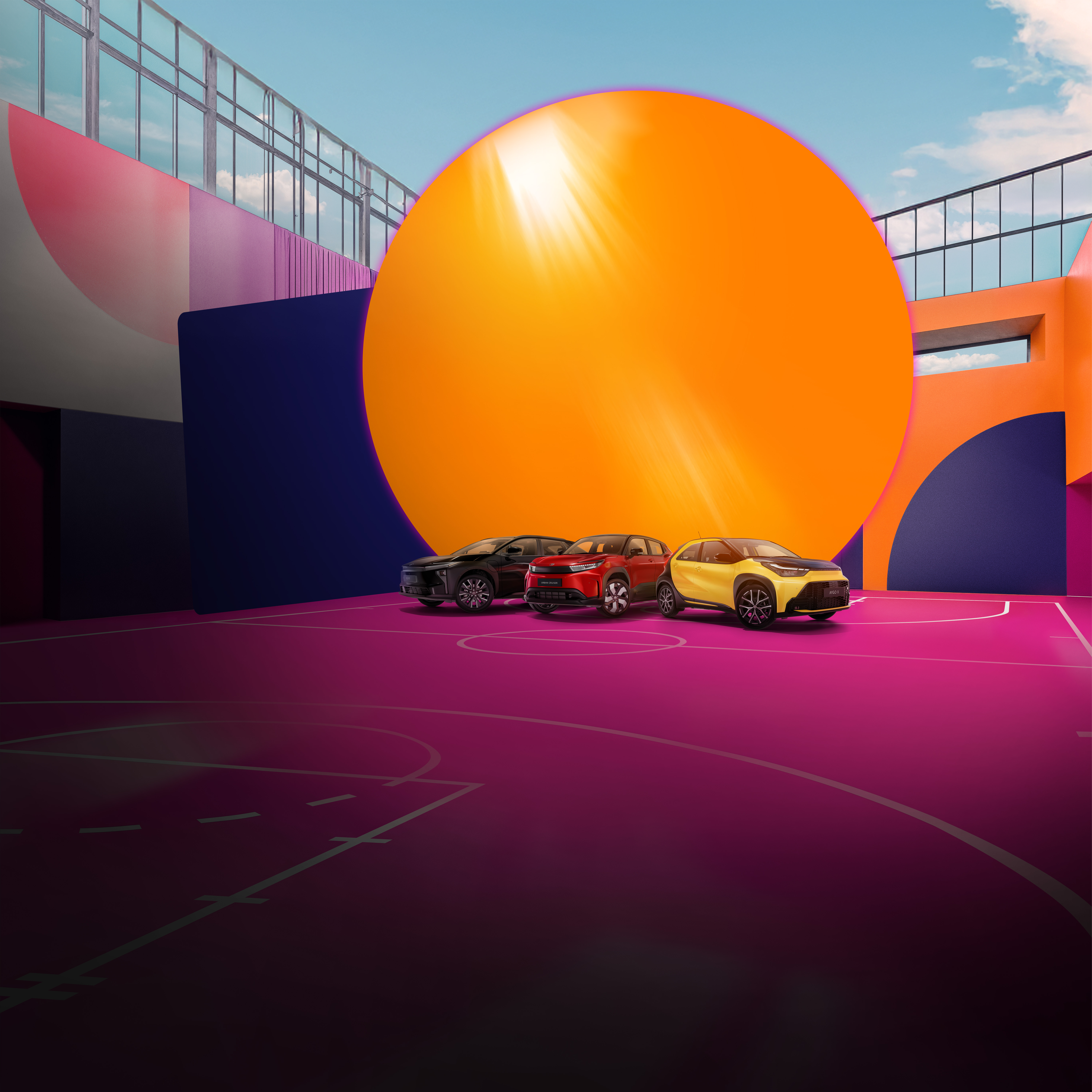 Vier Toyotas stehen auf einem pinken Basketballplatz, der von einer bunt bemalten Wand umgeben ist