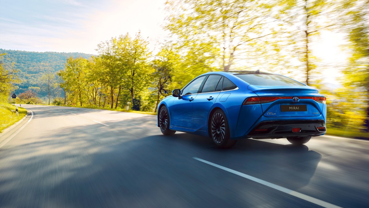 Blauer Toyota Mirai fährt auf Straße