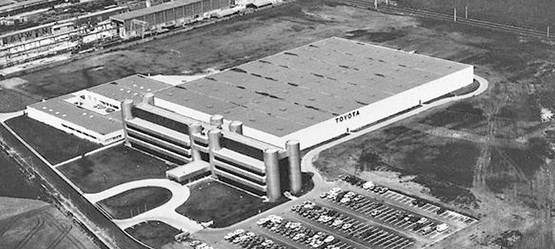 1979: Der neue Sitz von Toyota Deutschland wird in Köln fertiggestellt. Die Silhouette des Gebäudes ist in Form eines 8-Zylinder-Motors gestaltet.