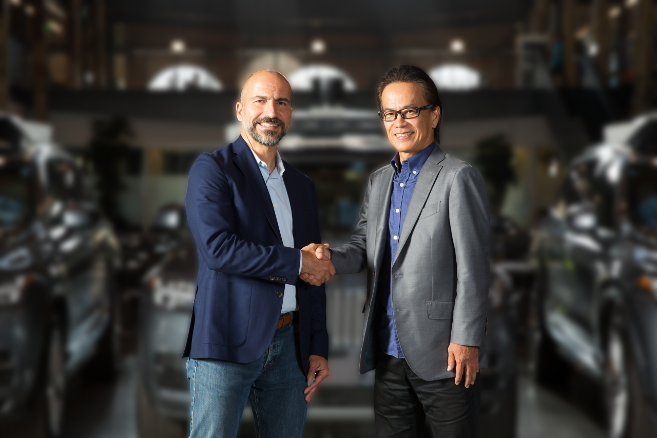 Shigeki Tomoyama, Executive Vice President von TMC & Dara Khosrowshahi, CEO von Uber schütteln sich die Hände