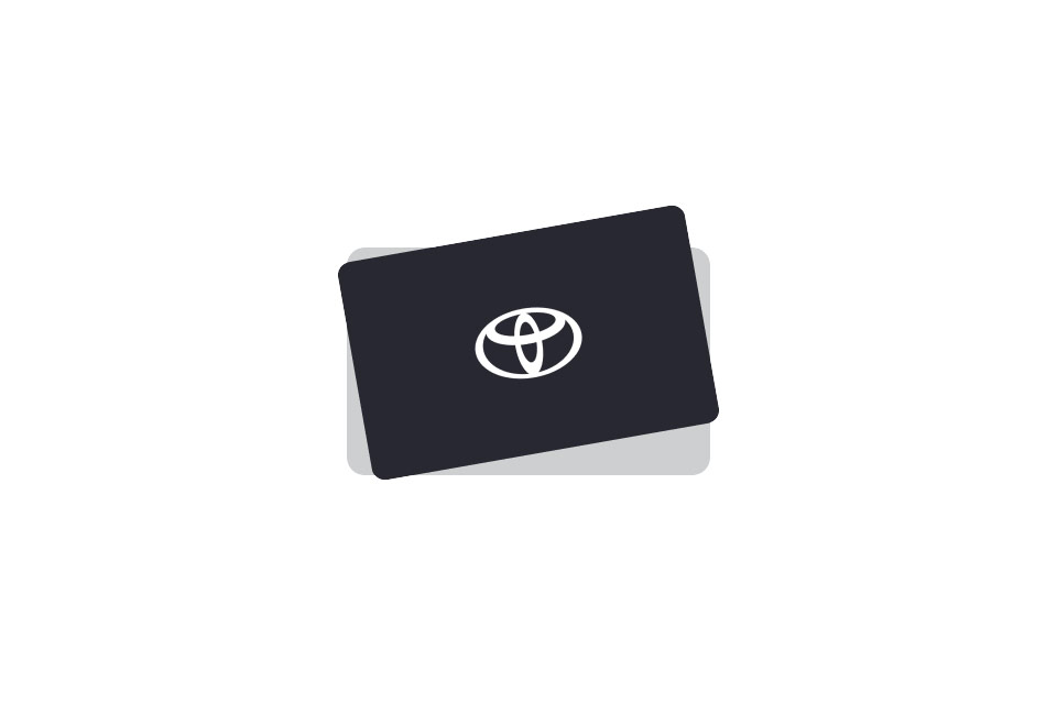 Schwarze Geschenkkarte mit einem weißen Toyota-Logo in der Mitte und einem dezenten grauen Hintergrund, der sich darüber legt