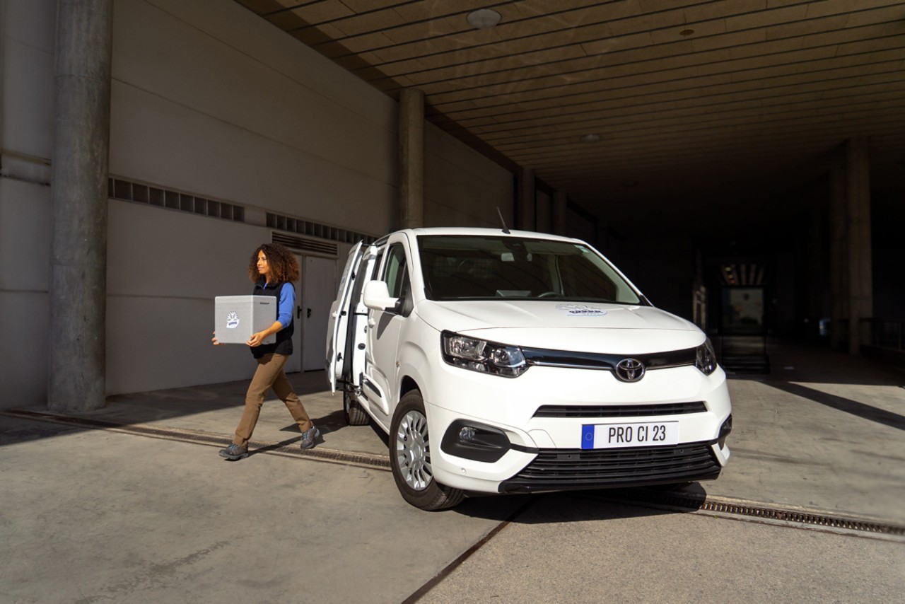Frau trägt eine Box aus dem Toyota Proace City