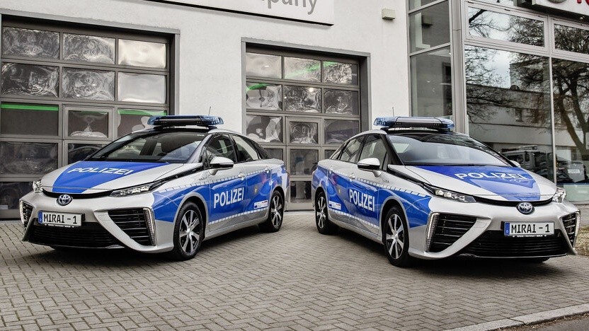Zwei Toyota Prius Streifenwagen vor einer Toyota Werkstatt