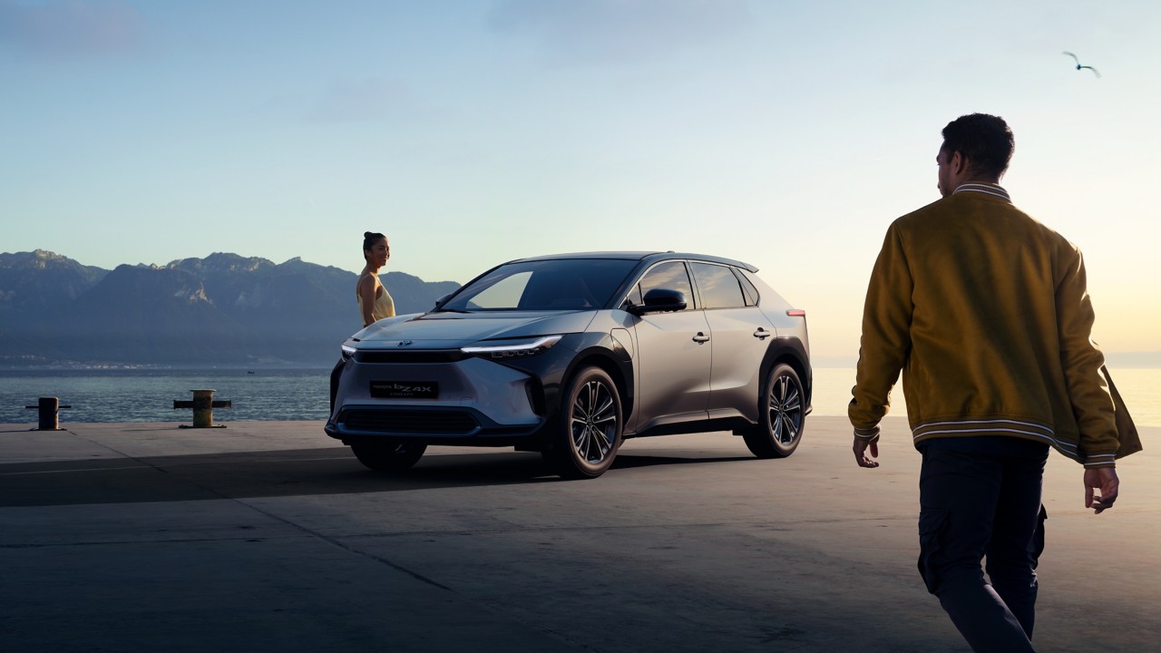 Junge Frau und Mann vor einem Toyota BZ4X