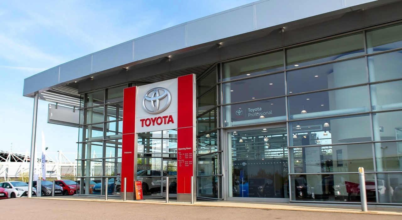 Ein Toyota Corolla Touring Sports und ein Toyota Corolla Hatchback vor einem Gebäude