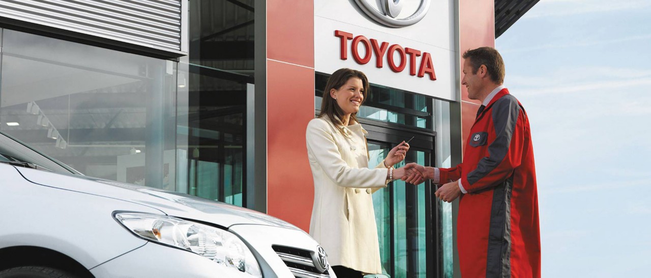 Toyota Service Mitarbeiter und eine Kundin bei der Schlüsselübergabe