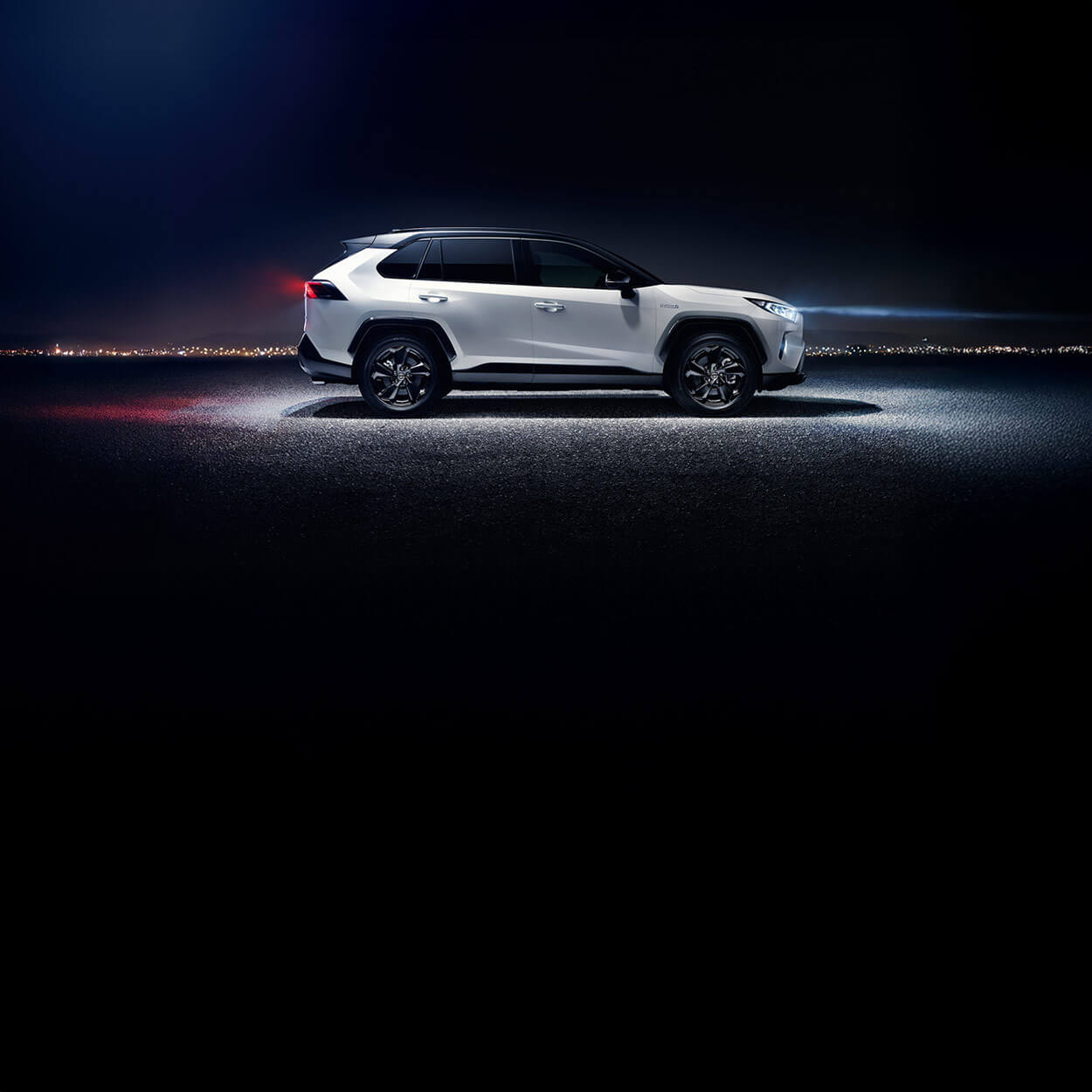 SUV mit weißer Lackierung und aerodynamischer Karosserie auf nächtlicher Straße