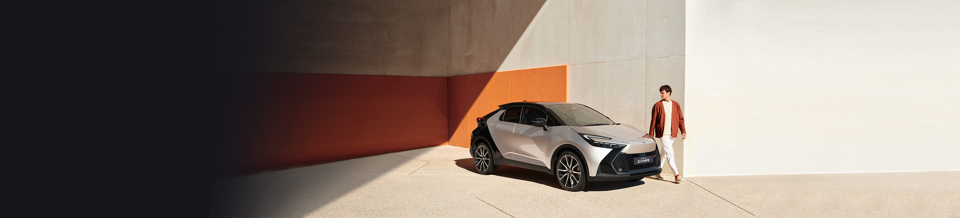Mann mit rotem Cardigan läuft am neuen Toyota C-HR entlang