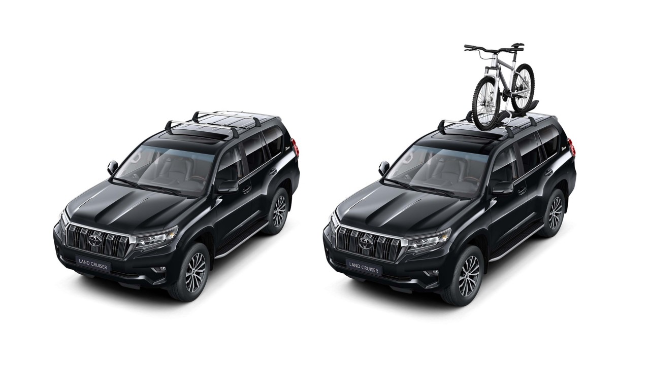 Zwei Land Cruiser mit Gepäckdach, einer mit Fahrrad auf dem Gebäckdach