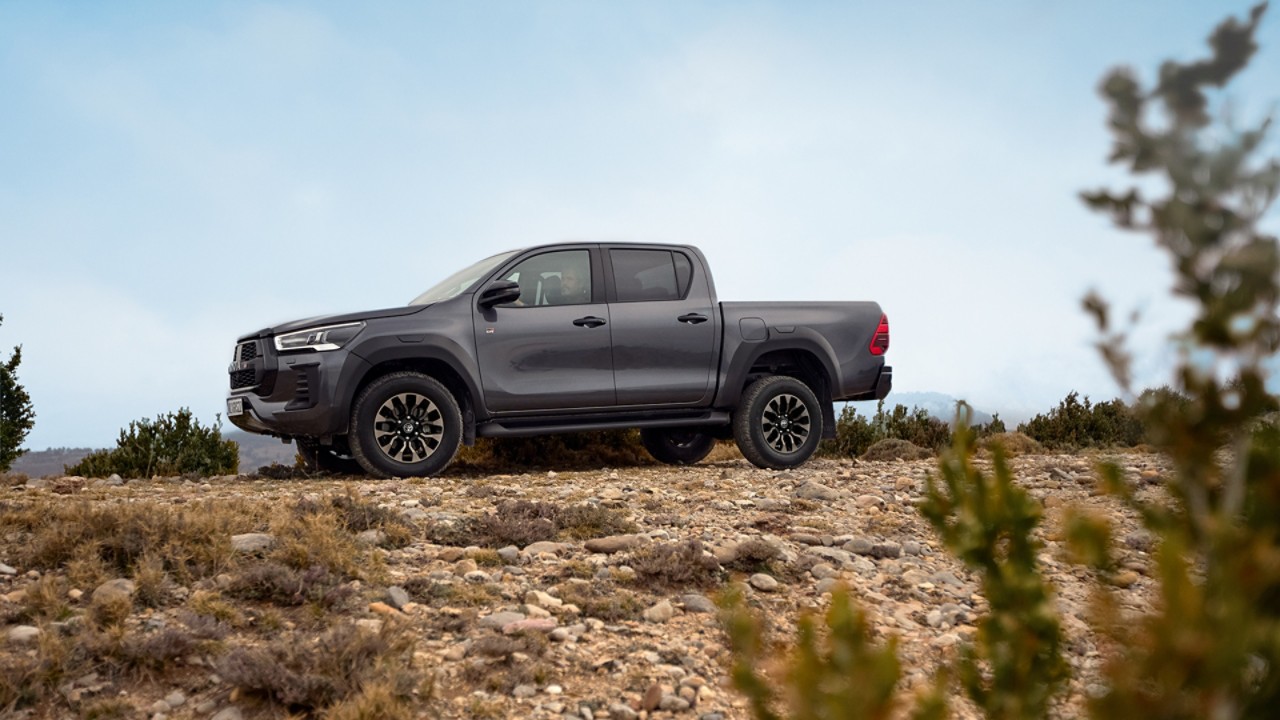 Mann steht auf der Ladefläche eines Pick-Up Trucks