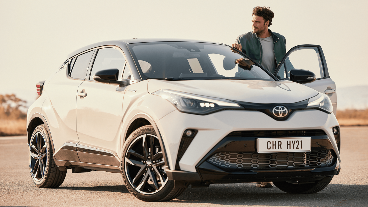 Mann steht neben Toyota C-HR Hybrid