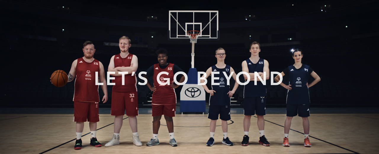 Sechs junge Athleten stehen vor einem Basketballkorb Titel: Let's go beyond