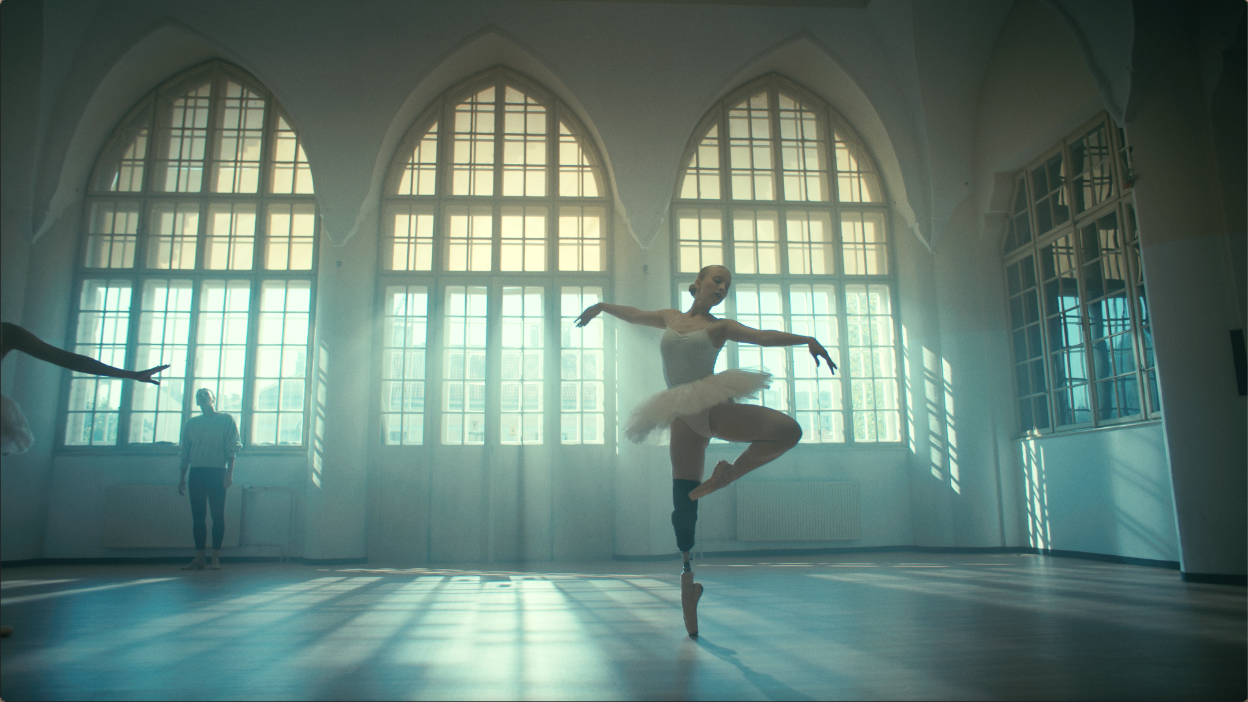Eine Ballet-Tänzerin mit Fußprotese tanzt in einem lichterfüllten Studio