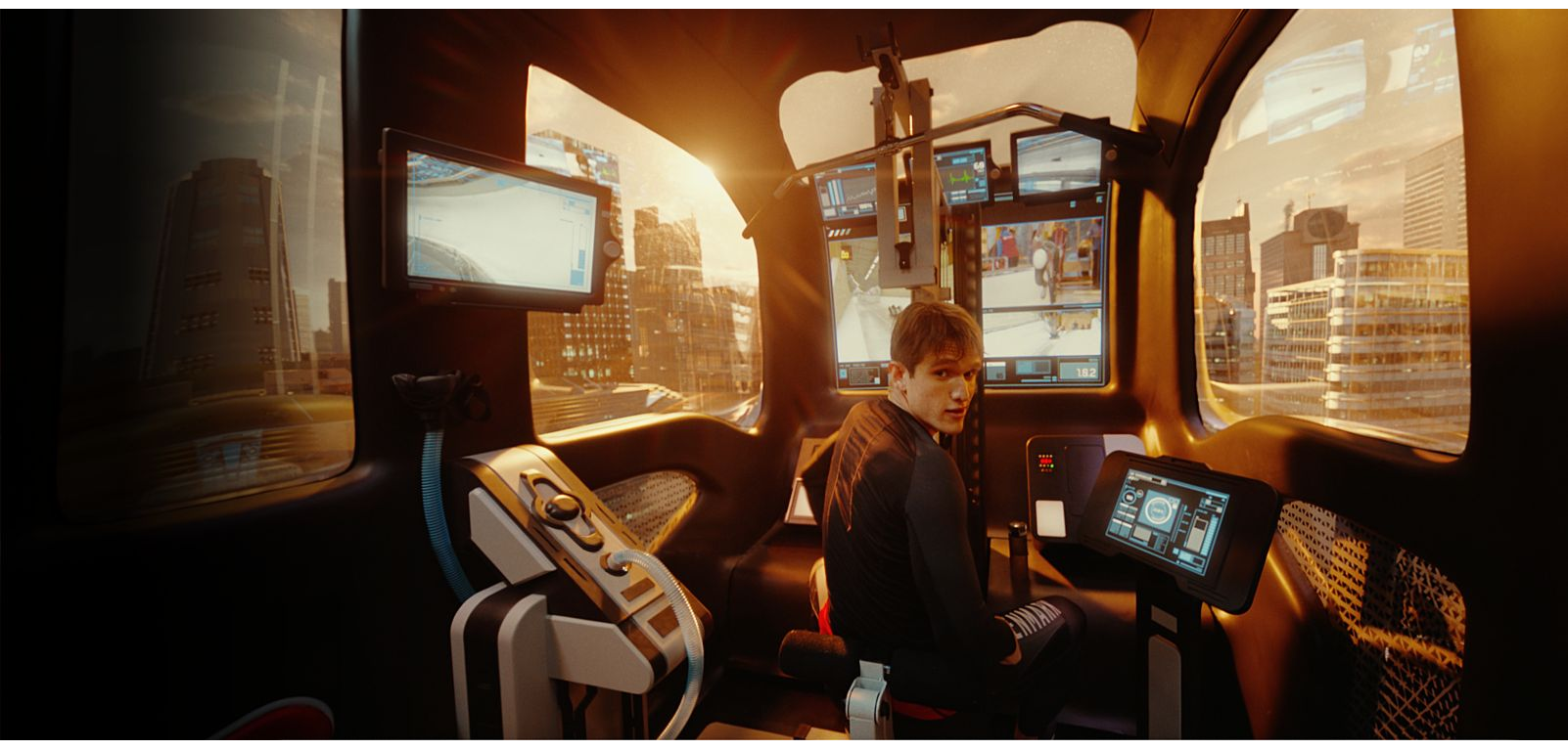 Blick auf einen jungen Mann, der im futuristisch aussehenden Cockpit einer e-Palette sitzt und sich zur Kamera zuwendet.