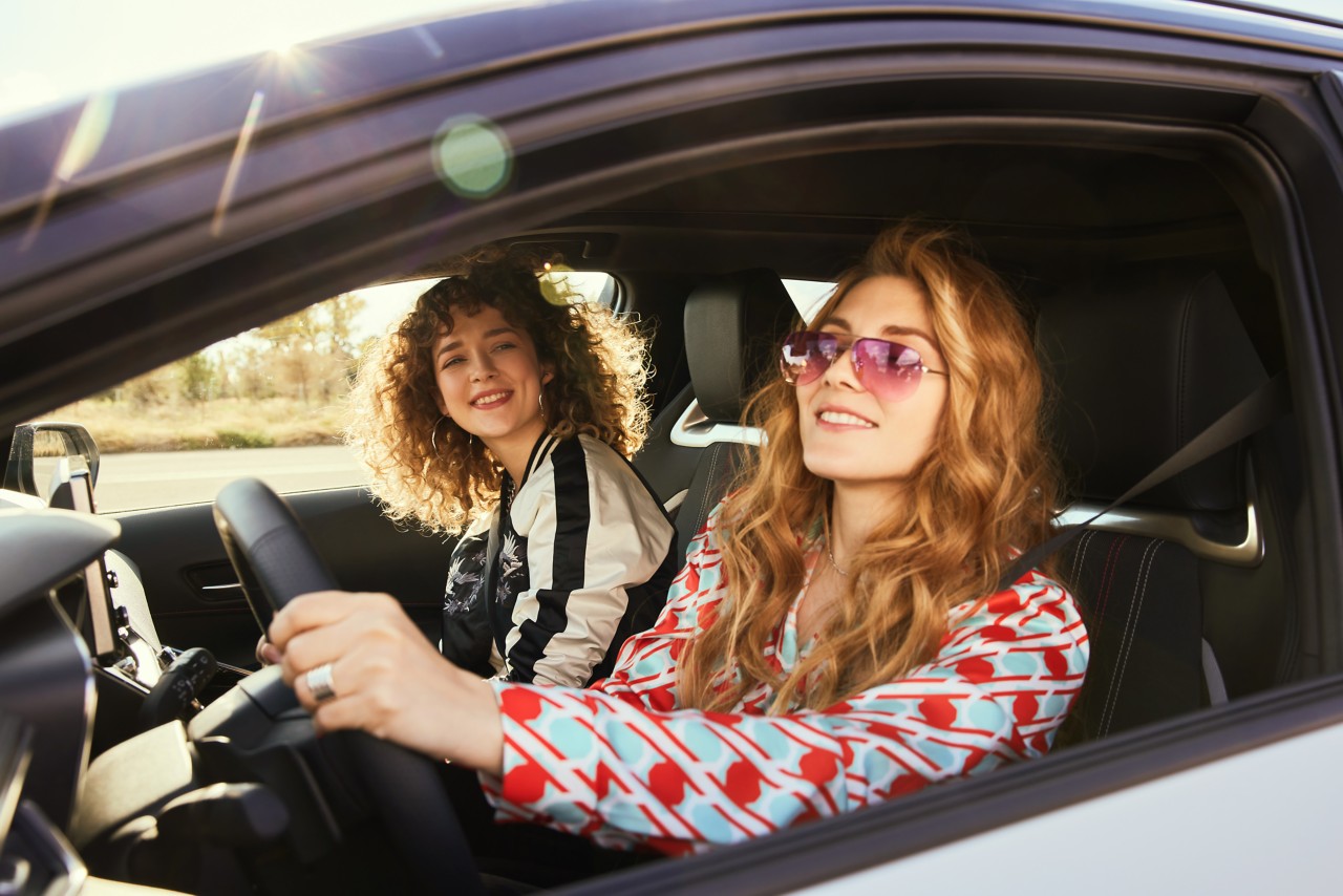 Zwei Frau fahren in einem Toyota bei Sonnenschein