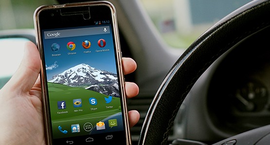 Hand hält Smartphone im Auto
