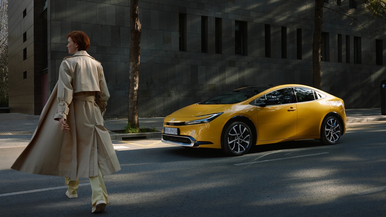 Frau läuft zum Toyota Prius