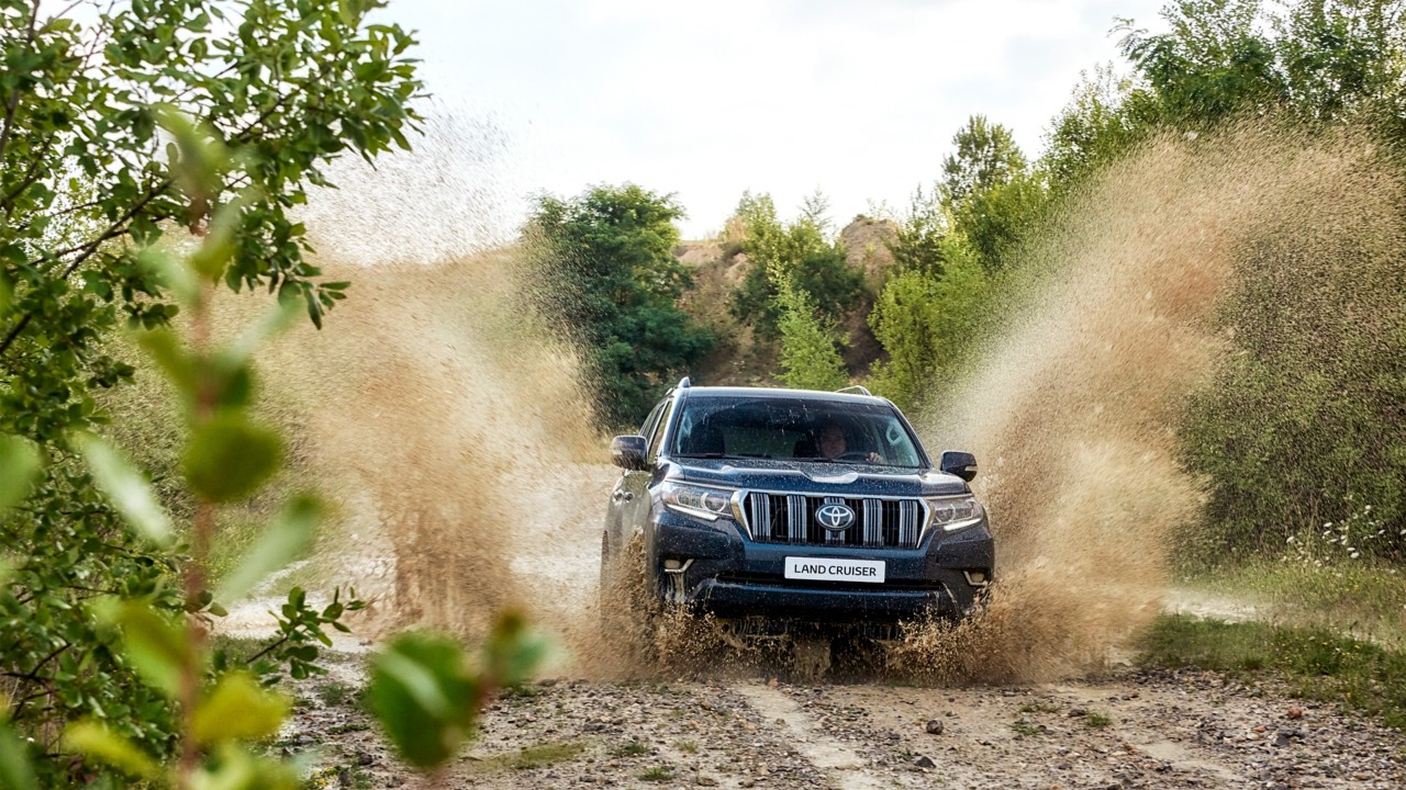 Schwarzer Toyota Land Cruiser fährt über Schlamm