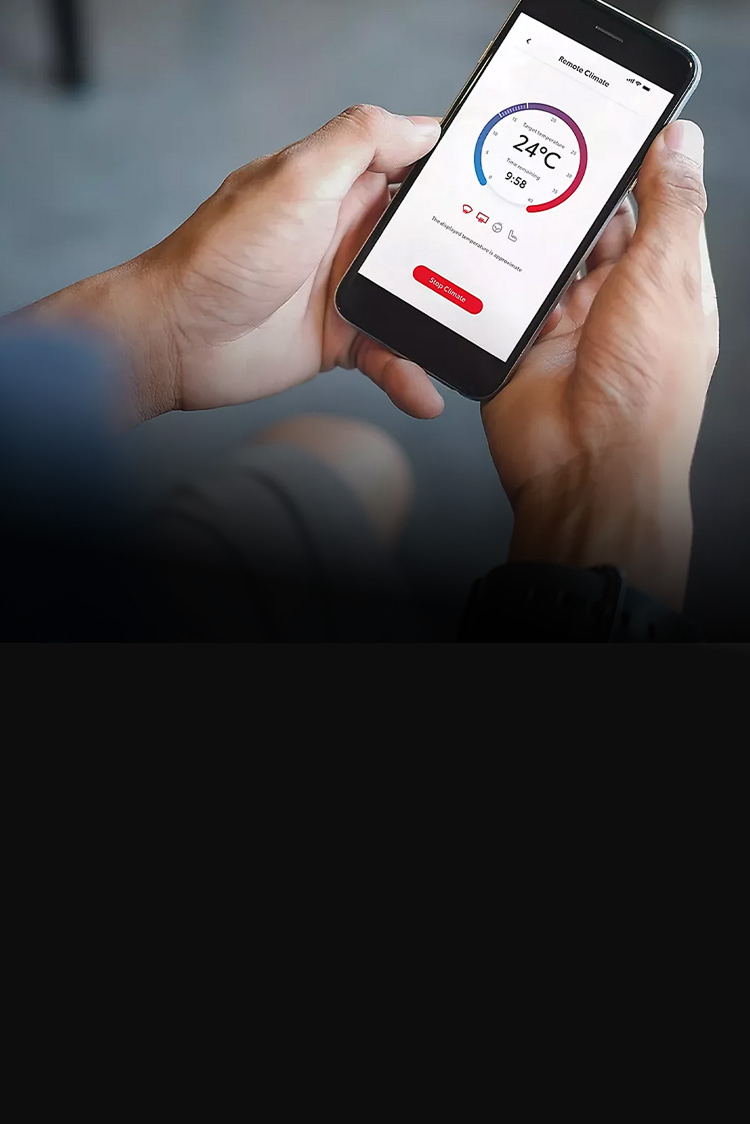Smartphone in der Hand einer Person, darauf eine App zum Bedienen der Klimatisierung zu sehen.