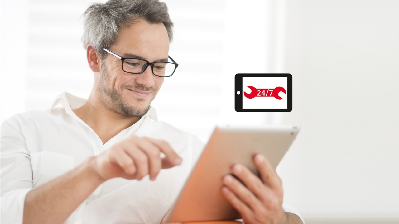 Mann beim benutzen eines Tablets, 24/7 Online-Service Logo