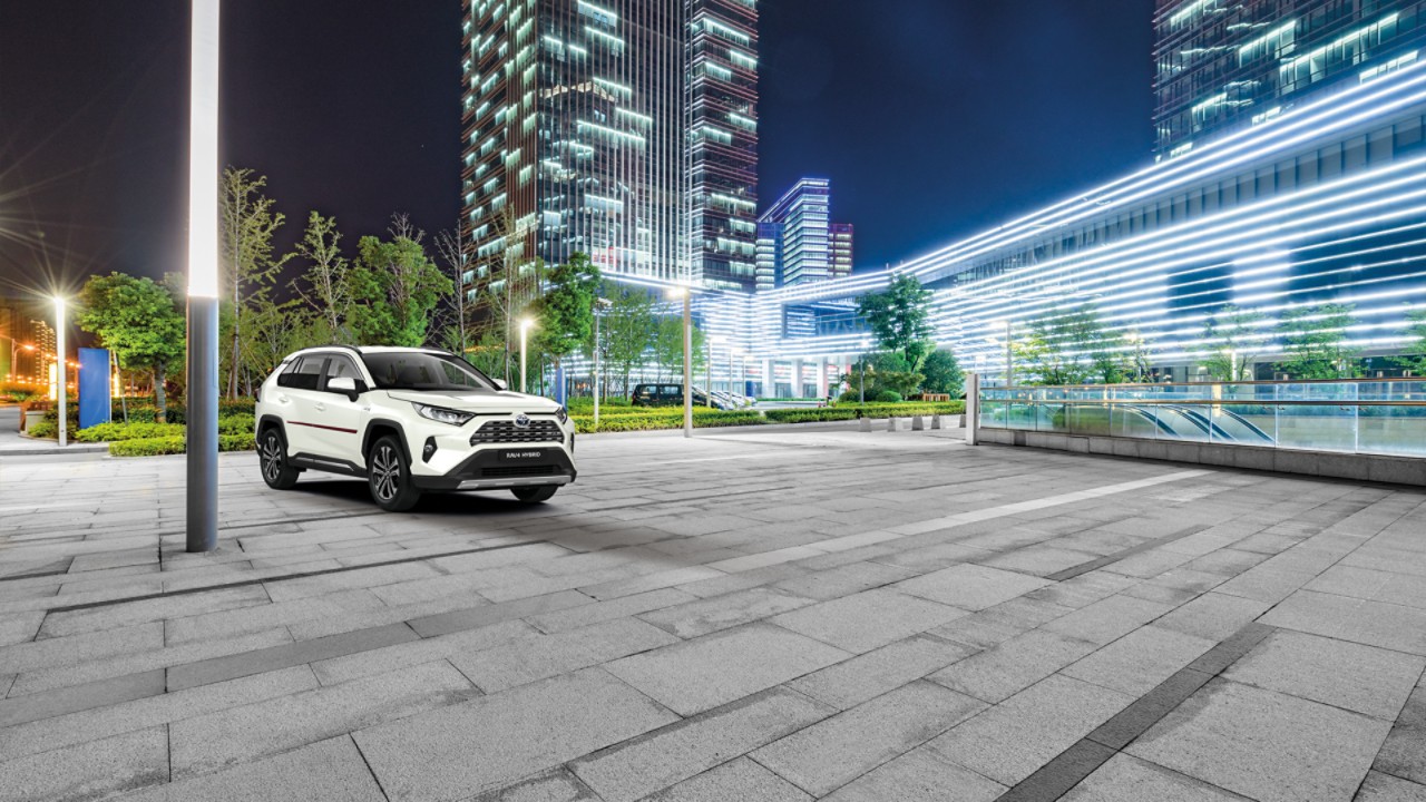Weißer Toyota RAV4 Hybrid steht auf Parkplatz