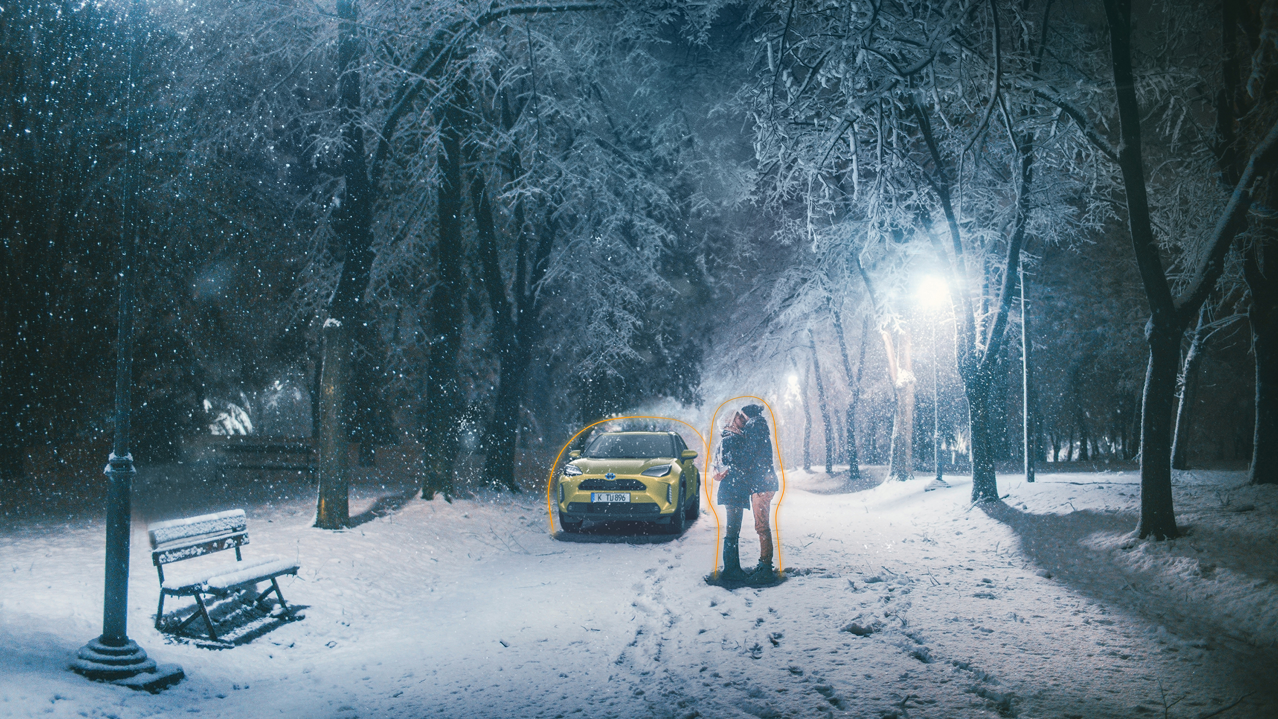 Paar umarmt sich in Winterlandschaft, gelber Toyota C-HR im Hintergrund